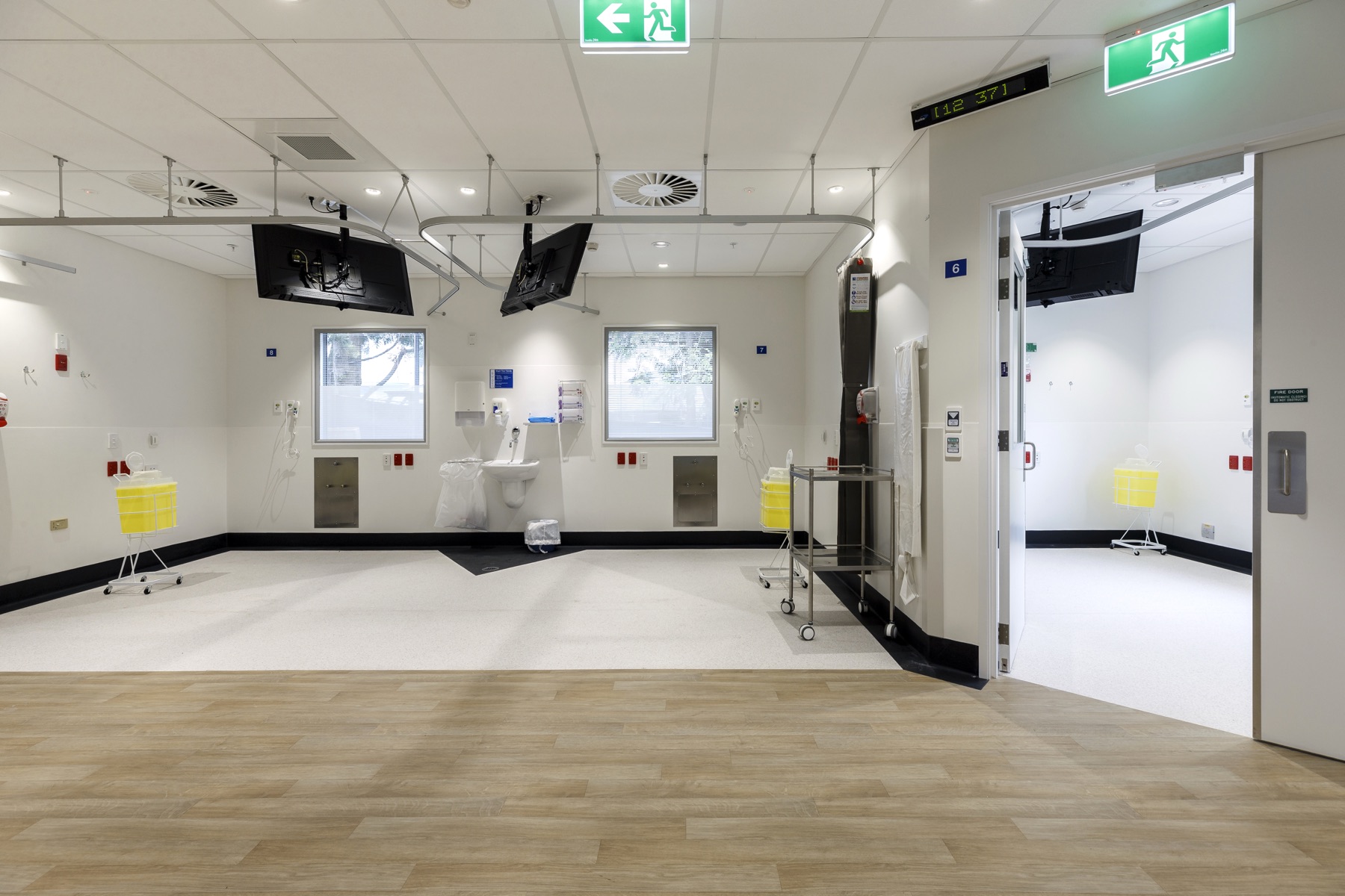 A finished, empty treatment room at Nelson Hospital with windows, wall-mounted screens and a clean floor